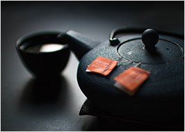 Teekanne und -schale mit gruenem Tee