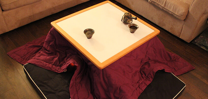 Tisch mit Decke und Sitzplätzen auf Boden