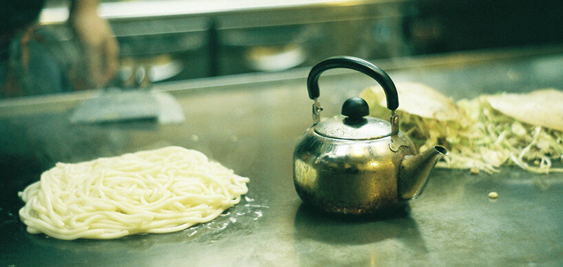 Okonomiyaki Streetfood Nudeln und Teekanne auf Kochplatte