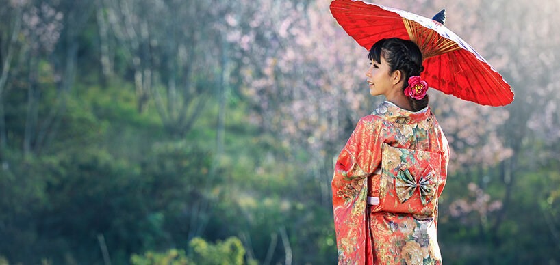 Geisha mit rotem Kimono und rotem Sonnenschirm